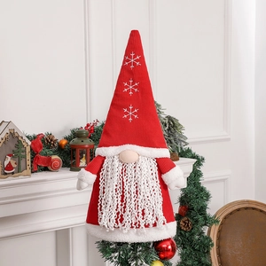 Nordic Christmas gnome with red snowflake hat and long beard on holiday fireplace