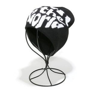 Close-up of black knit beanie with white jacquard the WORLD lettering on wire display