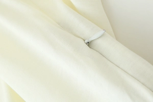 Vue macro détaillée du tissu blanc crème avec fermeture éclair invisible et sans couture