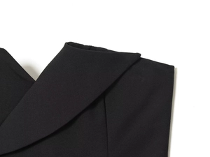 Gros plan détaillé sur la texture du tissu noir et la coupe du décolleté du haut