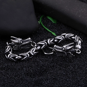 Macro shot of punk style dragon head clasps on a heavy oxidized stainless steel men's bracelet