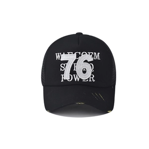 Détail de casquette vintage noire avec broderie 76 et visière jaune à effet usé vieilli
