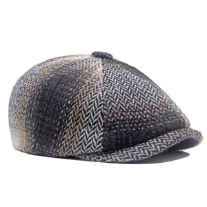 Detailed view of grey herringbone newsboy cap showing wool blend texture and curved brim