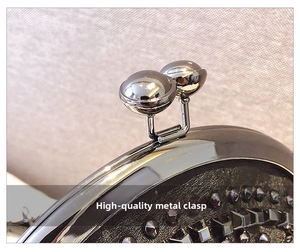 Close-up of gun-black double bead clasp and square rivets on black leather shell bag