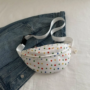 White canvas waist bag with colorful polka dots over a denim jacket lifestyle shot