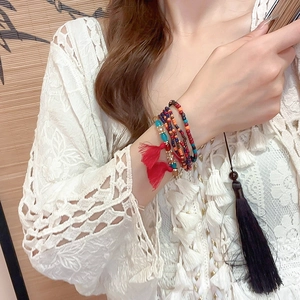 Detail view of Bohemian multi-layer beaded bracelet with red tassels and colorful beads