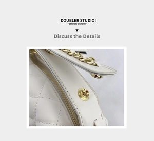 Macro shot of white quilted leather texture with gold chain and metal buckle details