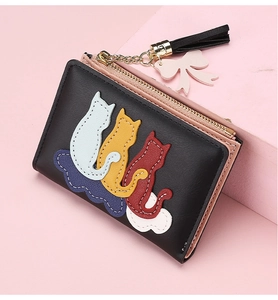 Detailed view of black litchi grain leather wallet with cat embroidery and pink tassel