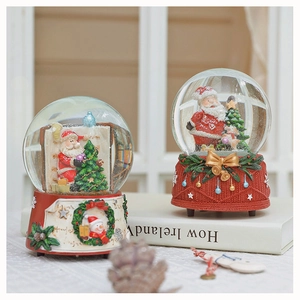 Detail of Christmas snow globe with resin base and snowman figure on white books