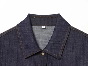 Detailed close-up of dark blue denim collar with contrast stitching and size S label