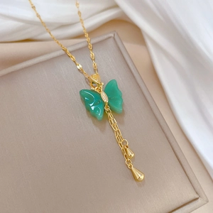 Detail of gold plated butterfly pendant with green jasper and long tassel drops