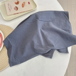 Detail of dark blue cotton linen placemat showing natural texture and neat stitching