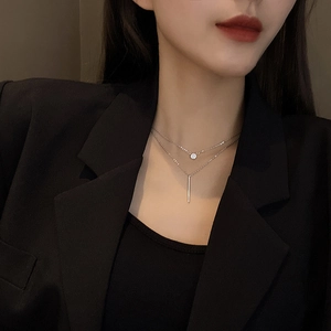 Close-up of double layer titanium steel necklace with round and vertical bar pendants