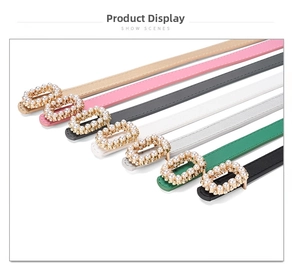 Detail view of seven slim dress belts with elegant faux pearl inlaid metal buckles