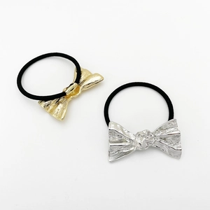 Detailed view of gold and silver alloy bow hair ties with black elastic bands