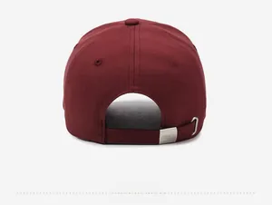 Detail of adjustable metal buckle with brand engraving on wine red cotton baseball cap