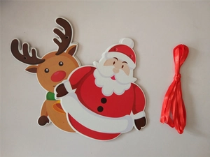 Detail of Christmas Santa and reindeer paper tags with red ribbon for festive decoration
