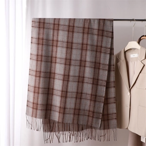 Close-up of brown and grey plaid cashmere-style scarf with tassel detail and soft texture