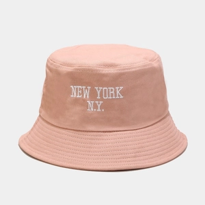 Close-up of pink cotton bucket hat featuring white NEW YORK N.Y. letter embroidery