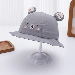 Close-up of baby sun hat featuring cute bear ear 3D design and detailed facial embroidery