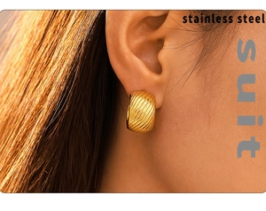 Close-up of a 18k gold-plated stainless steel C-shaped textured earring on ear