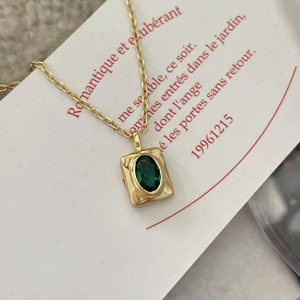 Elegant gold chain necklace with oval green gemstone pendant on a French card base