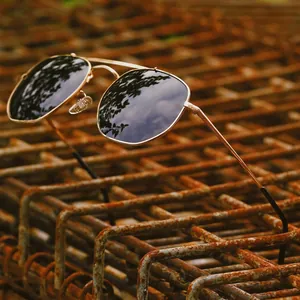 Polarized aviator sunglasses with gold metal frame on an industrial mesh background