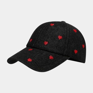 Détail de la broderie cœur rouge sur une casquette de baseball en denim noir texturé