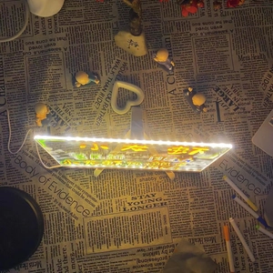 Close-up of LED glowing message board with wooden stand on newspaper background