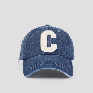 Close-up of navy denim baseball cap featuring a white chenille embroidered letter C patch