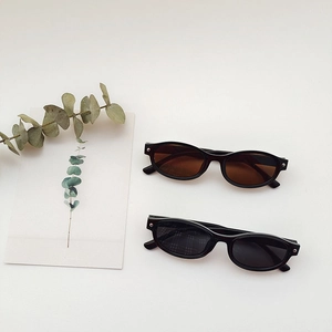Retro cat-eye children sunglasses set with black and tea lenses on a minimalist background