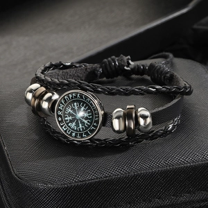 Macro shot of multi-layer leather bracelet with Nordic rune glass charm and metal beads