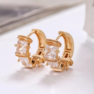 Macro shot of gold hoop earrings featuring square-cut micro-pave cubic zirconia stones