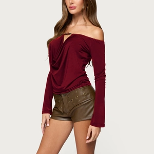 Detail view of burgundy draped cowl neck top with long sleeves and leather shorts