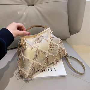 Detail of champagne gold evening bag featuring sequin embroidery and metallic fringe
