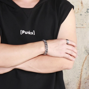 Close-up of men's vintage engraved cuban bracelet and matching ring set in street punk style