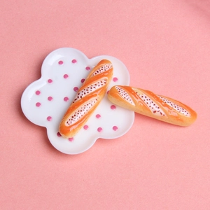 Vue macro de deux mini baguettes en résine sur une assiette nuage rose à pois