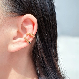 Gold chain ear cuff featuring a black rectangular zircon stone on a model's ear