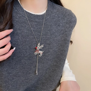 Detail of silver reindeer pendant with sparkling rhinestones and red accents on long chain