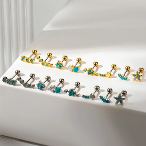 Detailed view of turquoise and crystal stud earrings in gold and silver finish on stand