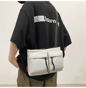 Close-up of lightweight nylon messenger bag with double front pockets and black zippers