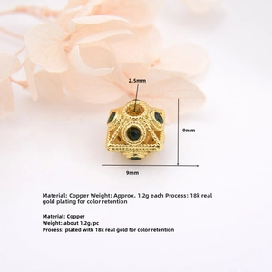 Macro detail of hollowed 18k gold-plated brass square bead with green gemstone inlay