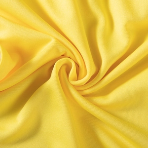 Close-up of yellow elastic mesh fabric showing soft knit texture and drape for sports shorts