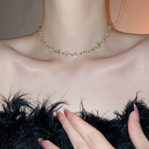 Detail of a gold floral choker necklace featuring sparkling crystals and a French vintage style