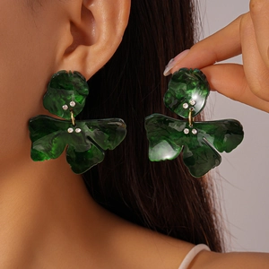 Green marble resin flower earrings with rhinestone accents shown on ear and hand