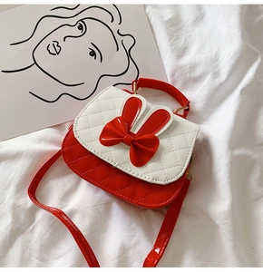 Detailed view of red and white quilted girls' bag with rabbit ears and bow decoration