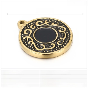Detail of 25mm round stainless steel pendant with gold textured edge and black resin inlay