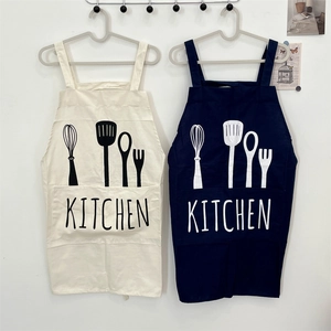 Close-up of minimalist cotton linen kitchen aprons with utensil prints and large pockets