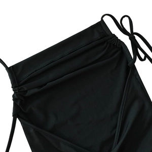 Close-up of ruched neckline and thin shoulder straps on the black backless maxi dress