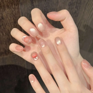 Pearlescent pink press-on nails with hand-painted red apple design and cat-eye finish